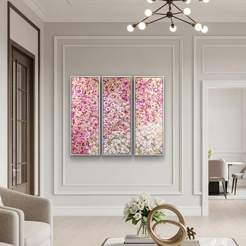 Spring Embrace triptych by Antonio Sannino featuring pink cherry blossom and gold leaf panels displayed in a contemporary interior